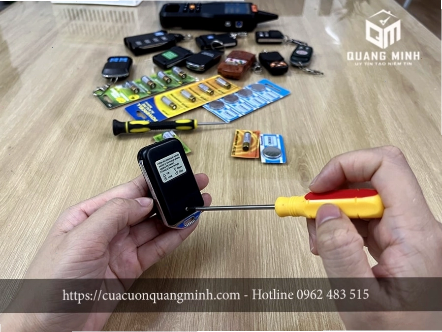 Thao tác tháo ốc vít bảo vệ remote cửa cuốn